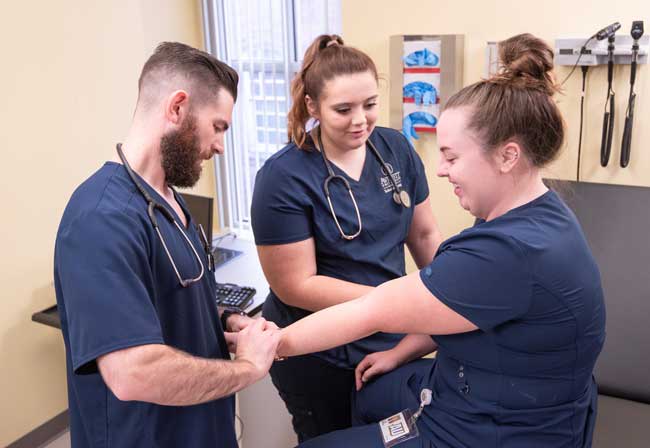 Averett nursing students in a skills lab learning to take each other's pulse on the wrist