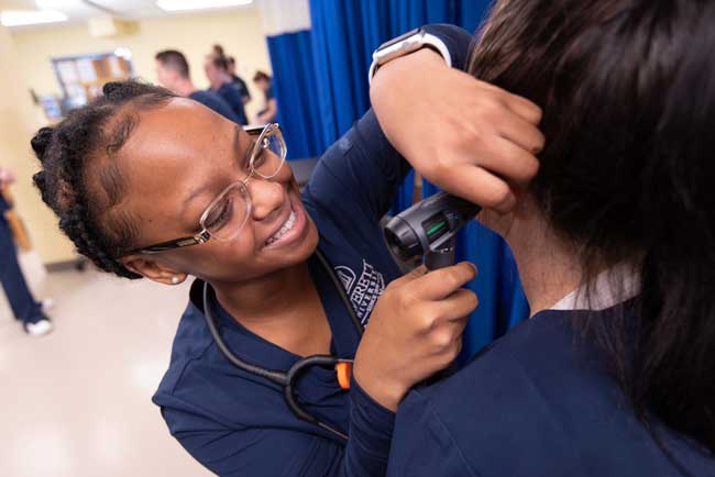 averett nursing student examining a patient's ear