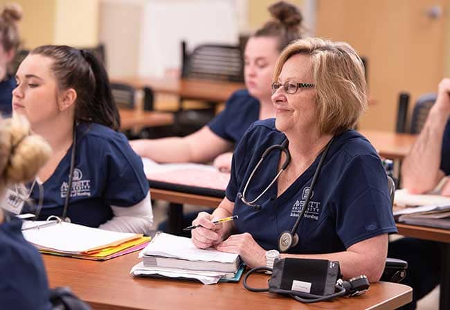 nursing student sitting in class with notebook