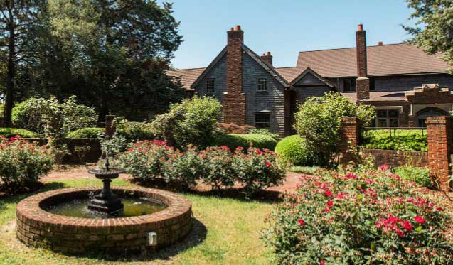 home backyard with flowers and a fountain