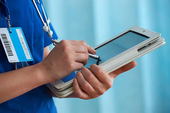 Nurse using a stylus on a digital tablet