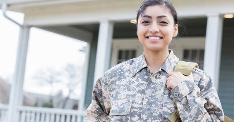 woman in camo uniform holding backpack