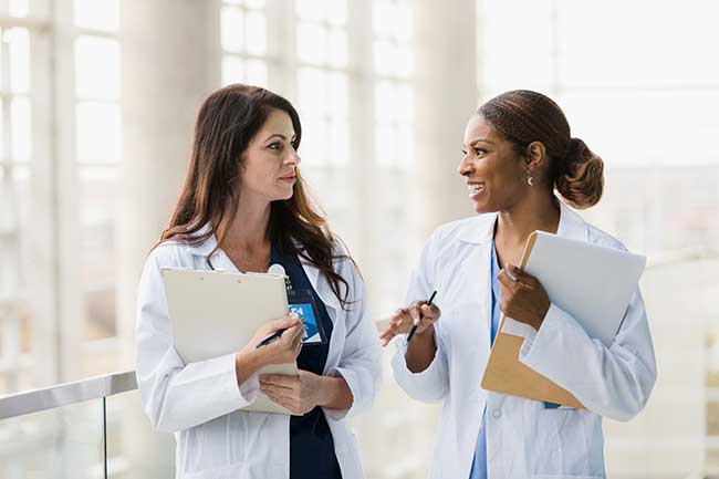 two nurses talking in hallway