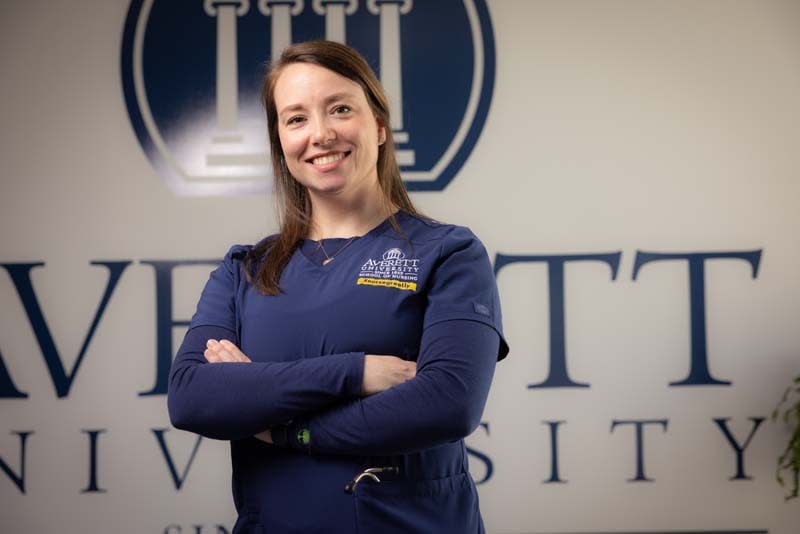 Averett ABSN student standing in front of university wall sign