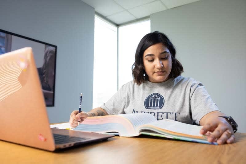 ABSN student reading textbooks