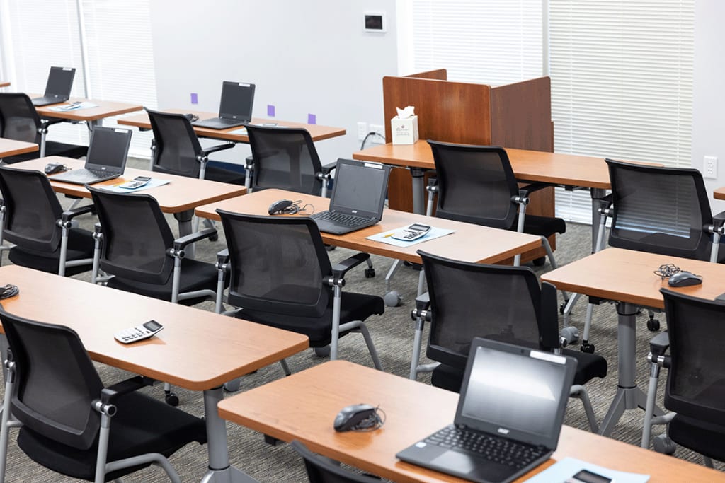 classroom with laptops and desks