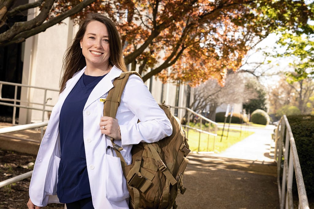 ABSN student standing outside holding backpack