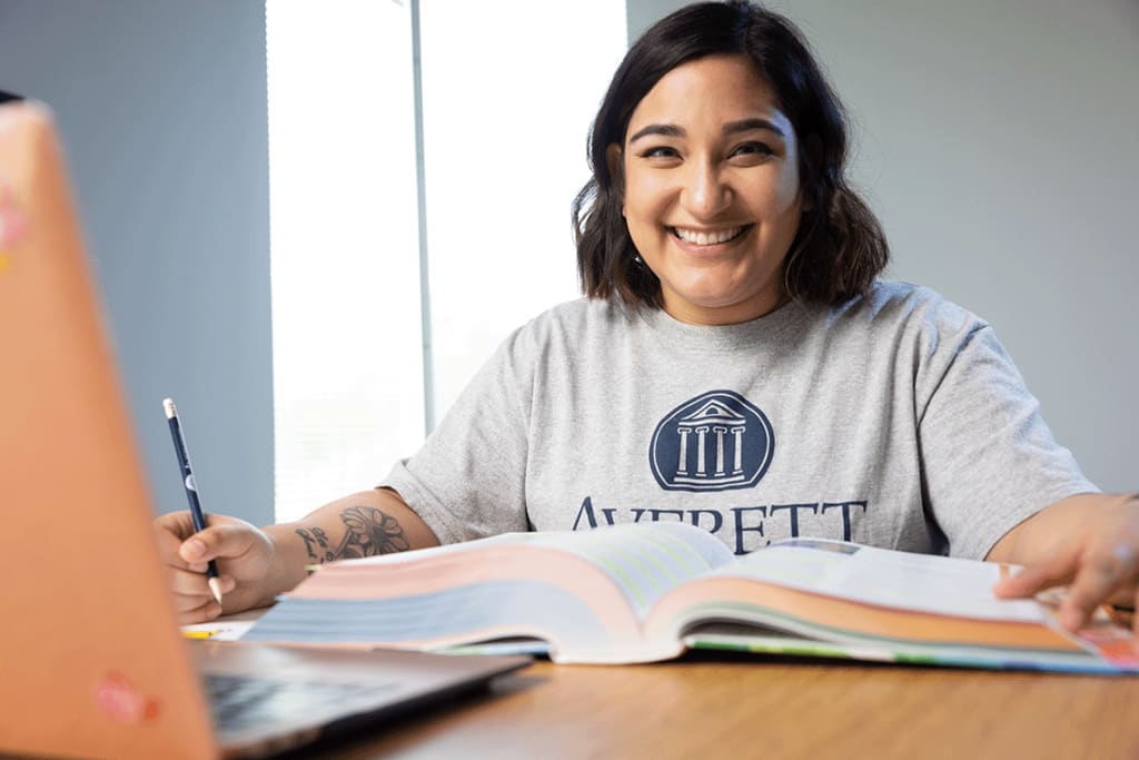 ABSN student at desk with textbook