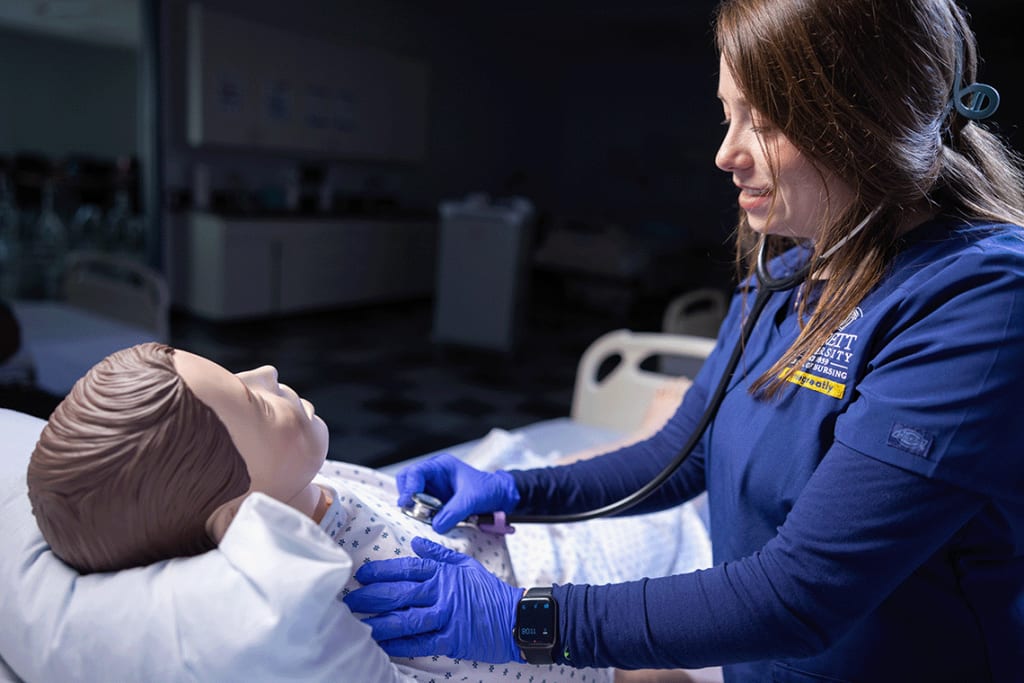 Averett nursing student working with sim manikin