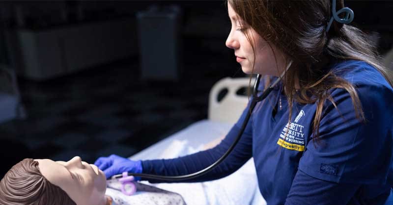 Averett nursing student working with sim manikin