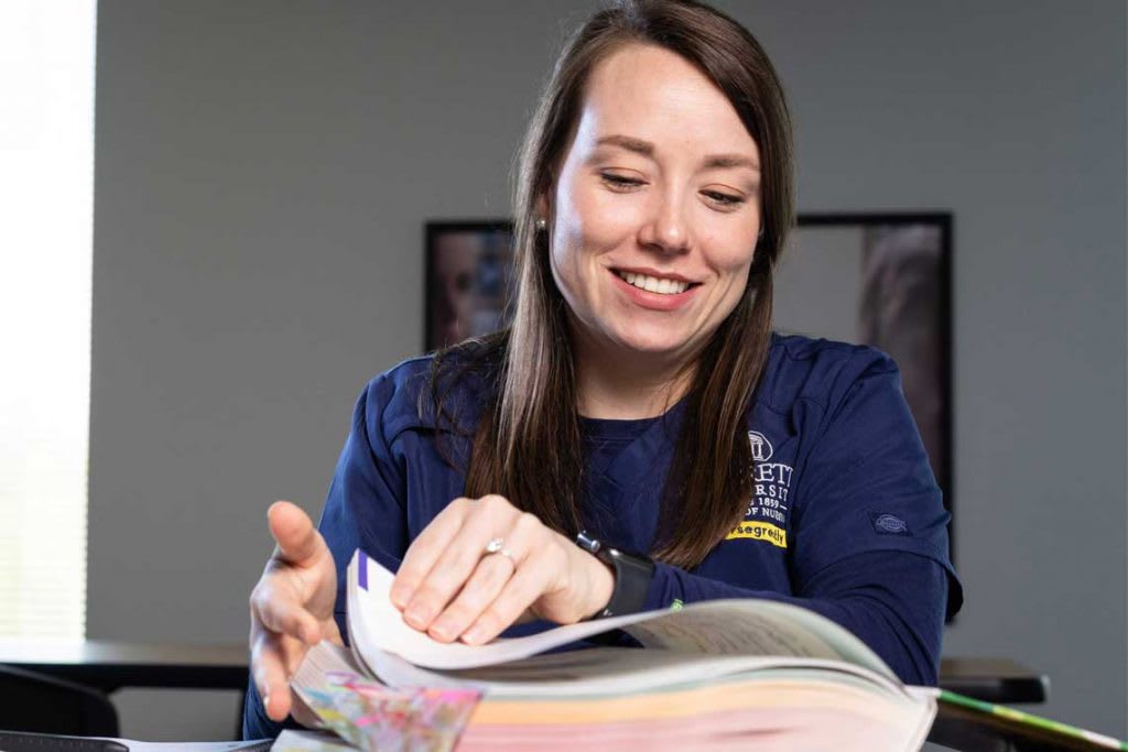 Averett nursing student sitting at desk with textbook