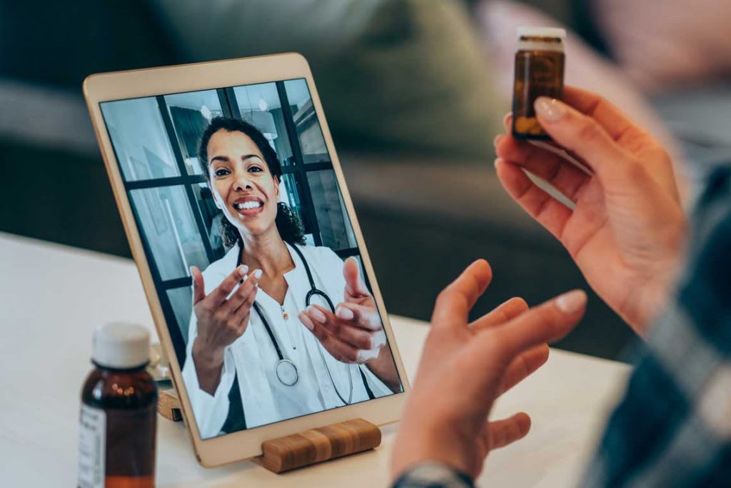 nurse on digital tablet speaking with their patient remotely