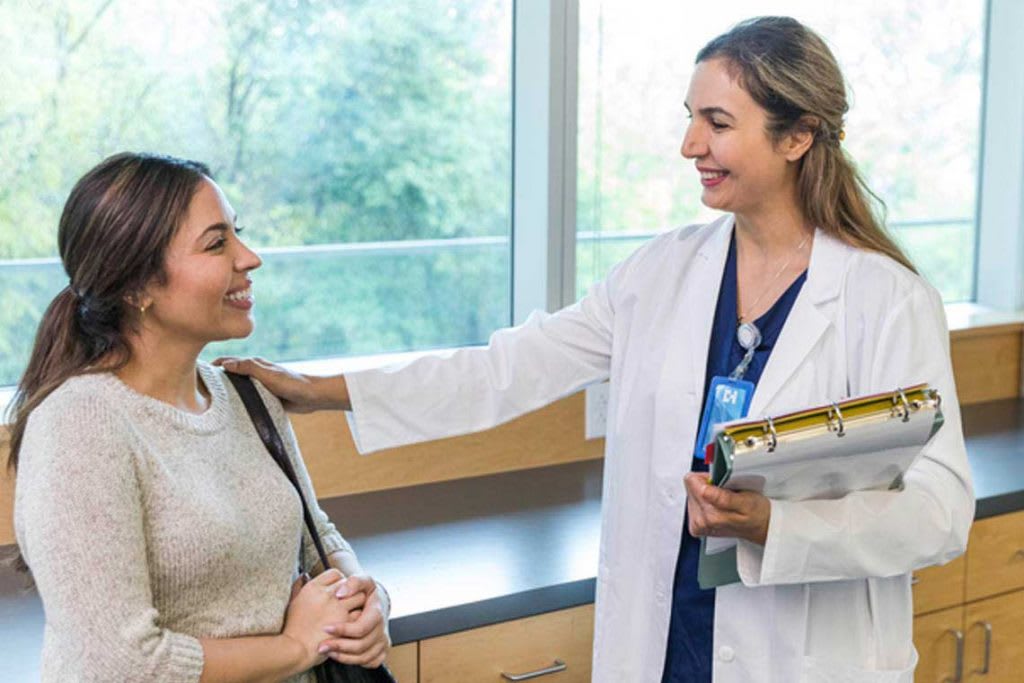 nurse putting her hand on patient's shoulder