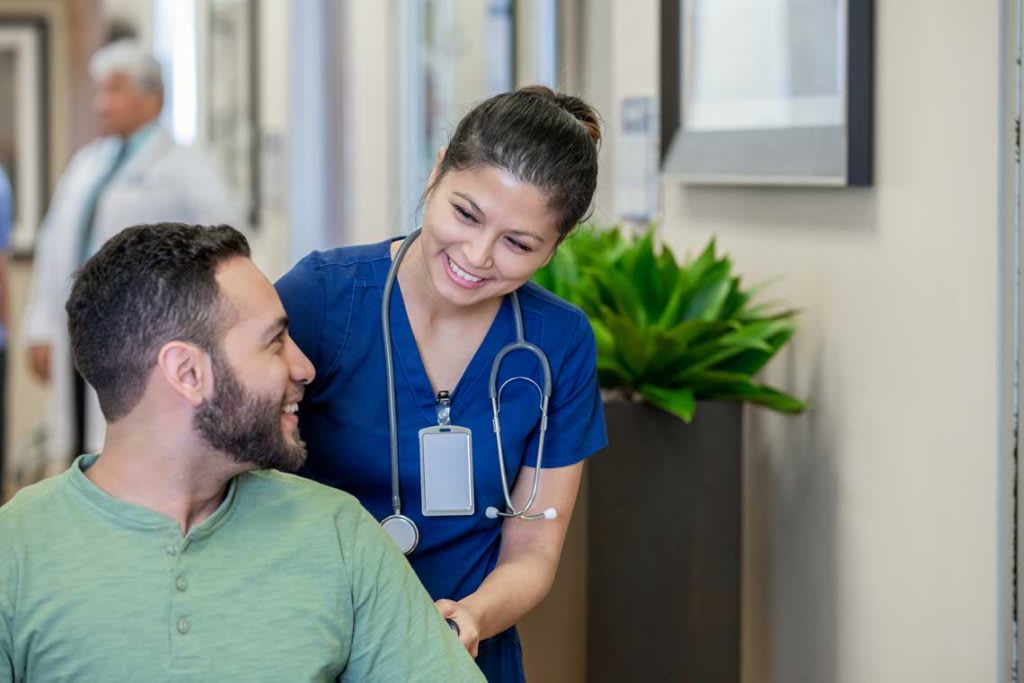 nurse in blue scrubs with patient