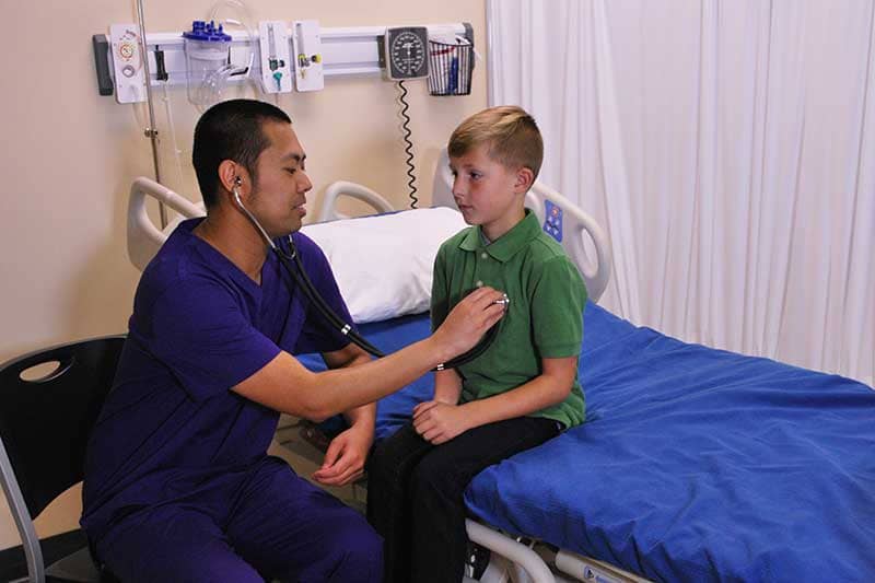 nurse using stethoscope with child patient