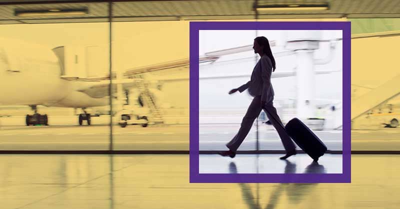 focus on woman walking in airport carrying luggage