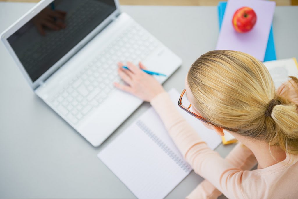 looking down onto a women on laptop