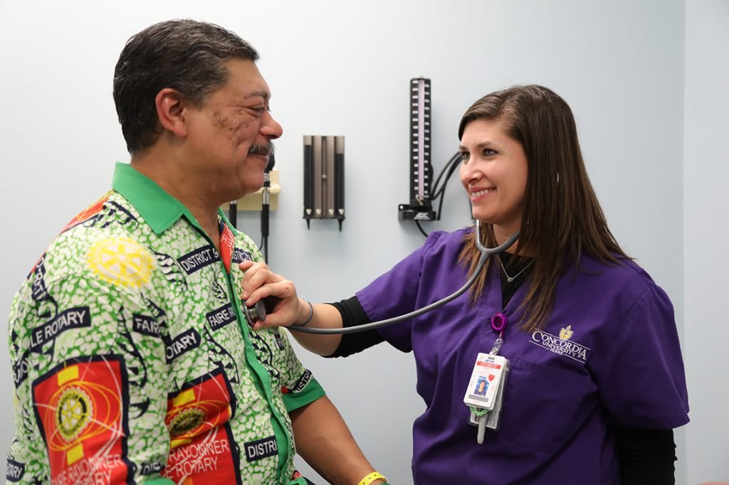 Nurse checking man's heart