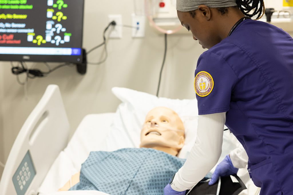 nursing student working with simulation manikin