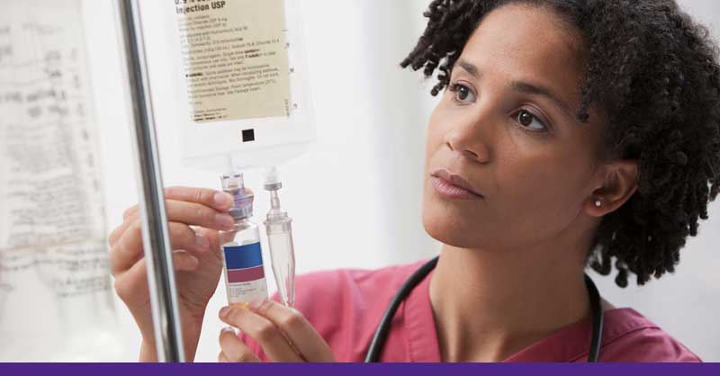 nurse looking close at IV bag