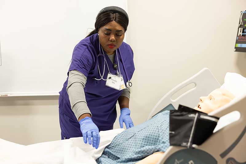 nursing student working with simulation manikin