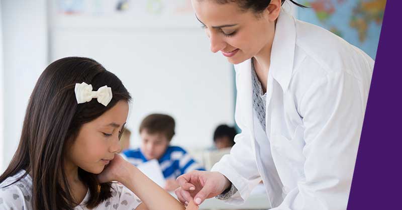 school nurse helping child with band-aid