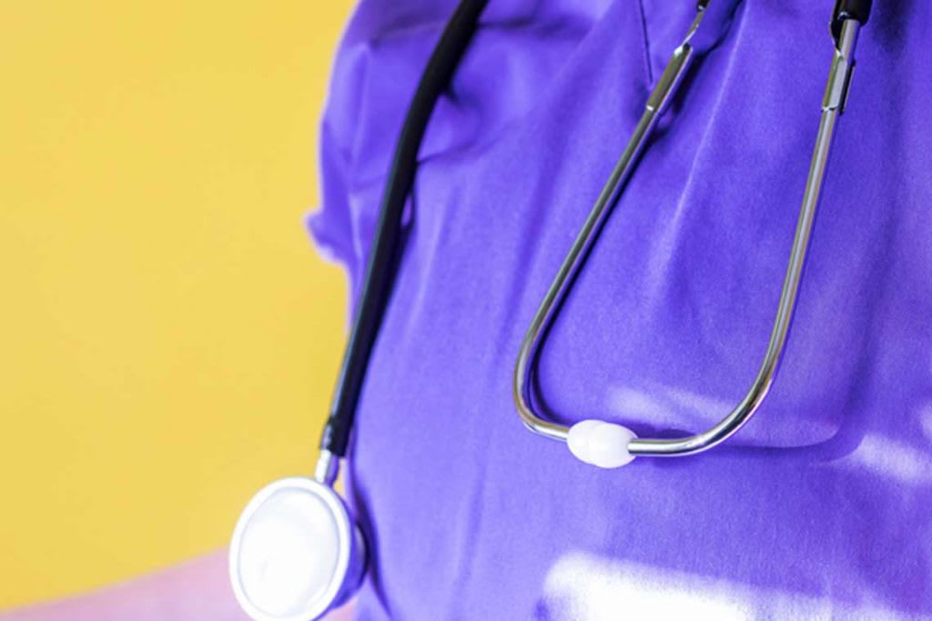 close up of nurse with purple scrubs and stethoscope