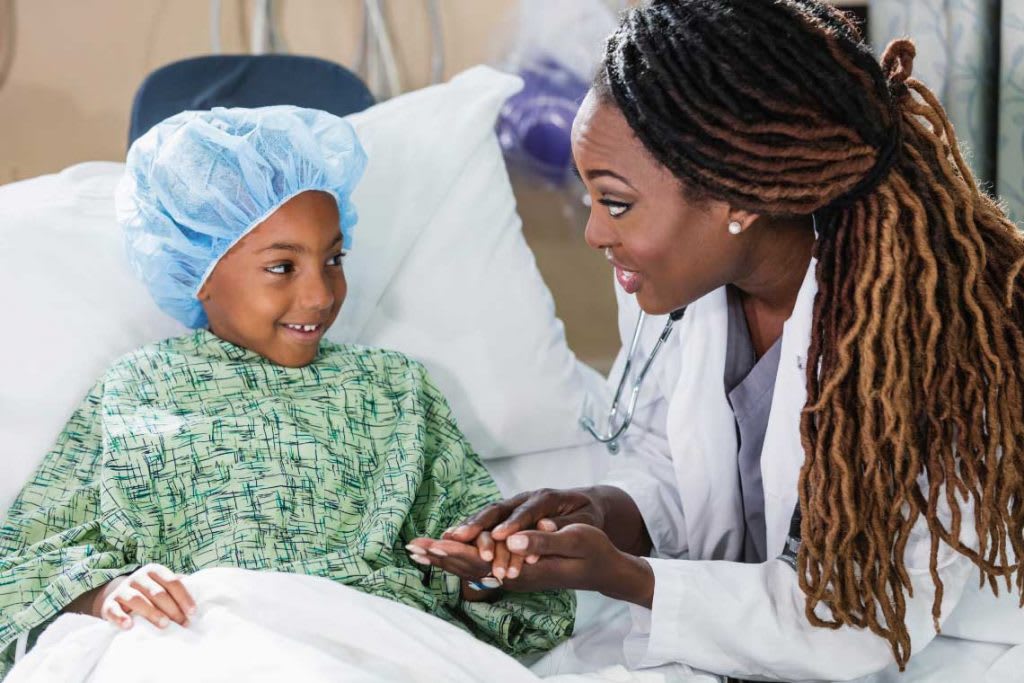 nurse next to child patient's bedside
