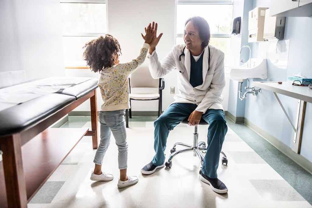 pediatric nurse high-fiving child patient