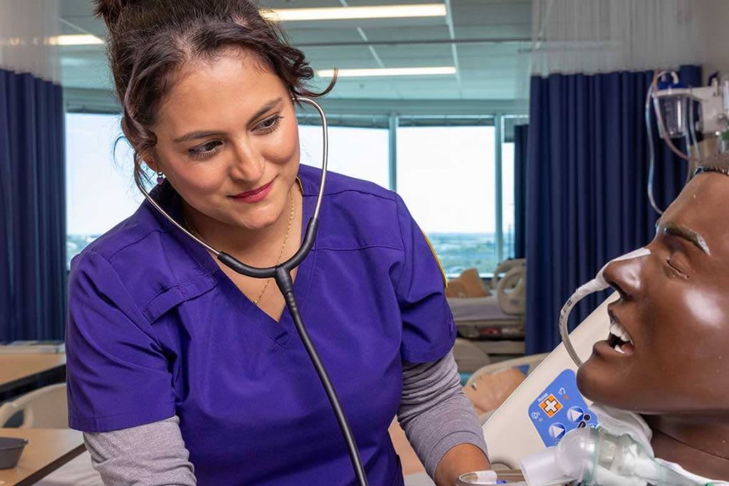 Concordia Texas nursing student working with sim manikin