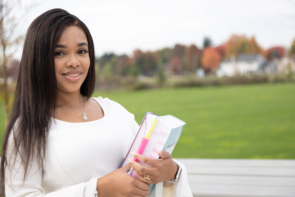 nursing student standing outside holding textbooks