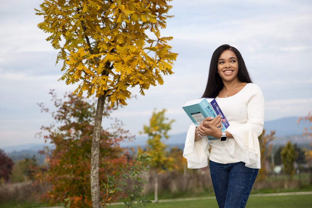 nursing student walking outside by tree