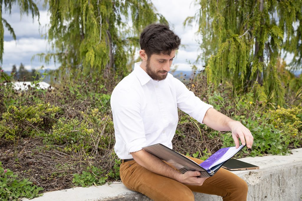 student sitting outside reading