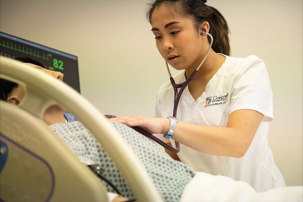 nursings tudent working with sim manikin