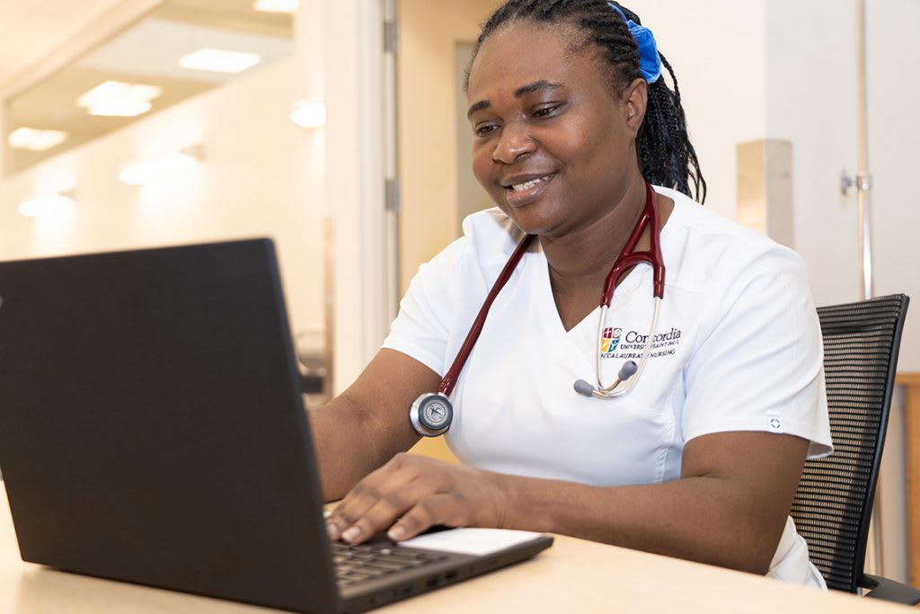 CSP nursing student sitting at desk using laptop