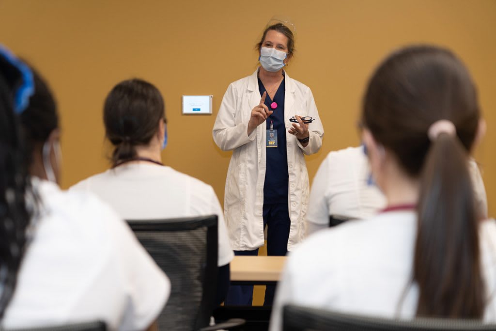 nursing instructor standing in front of classroom of students