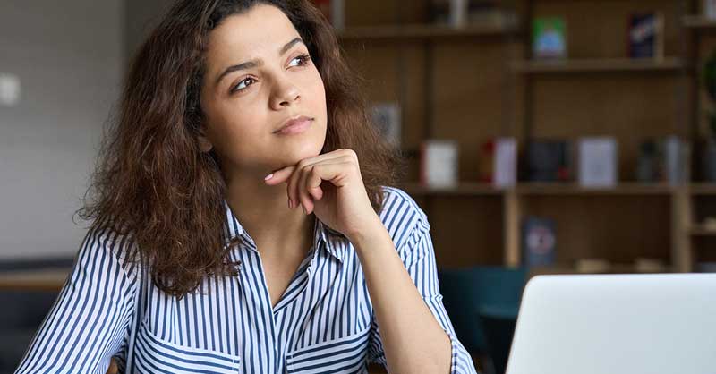 woman sitting at desk thinking