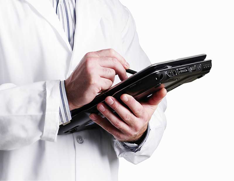 doctor in lab coat holding digital tablet