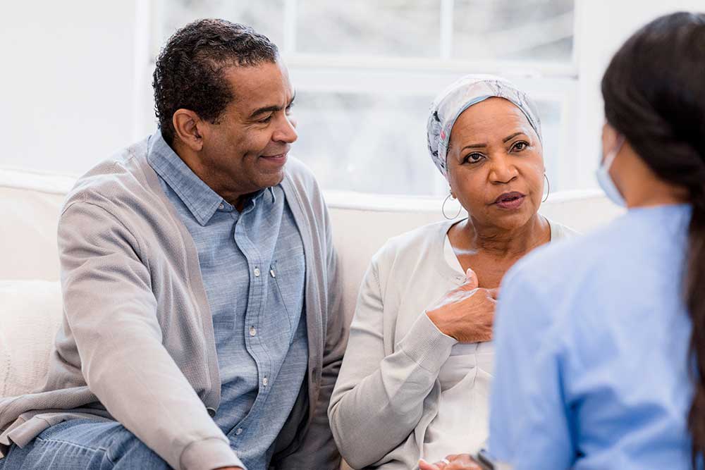 nurse sitting and talking with patient and her family