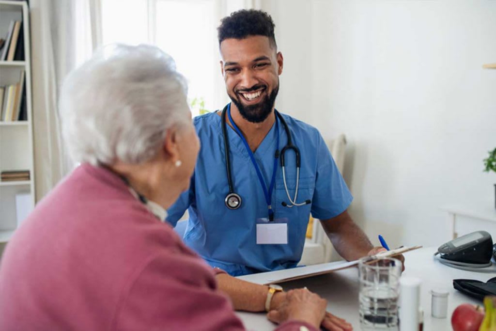 nurse smiling and talking with elderly patient