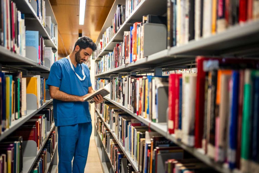 nursing student in library reading a book