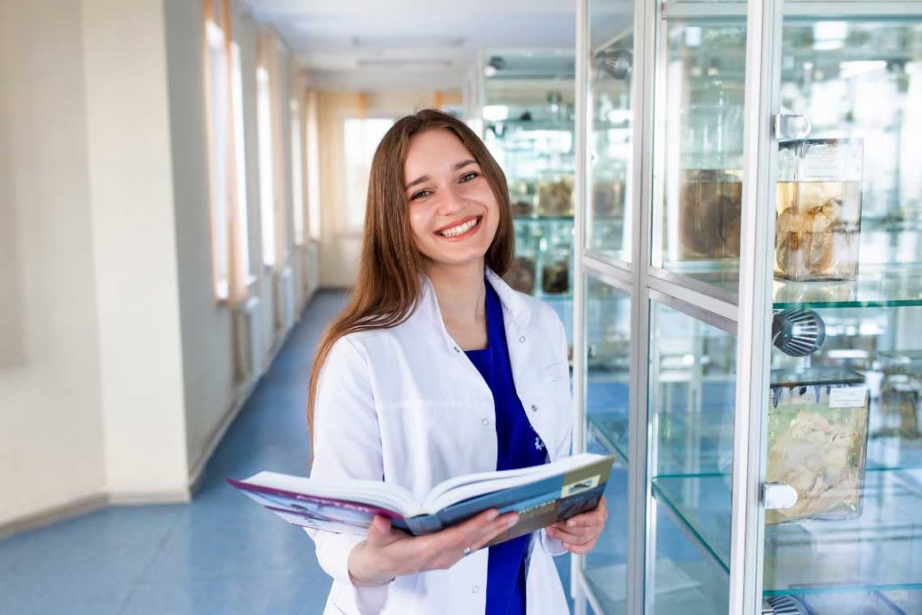 smiling nurse holding open book