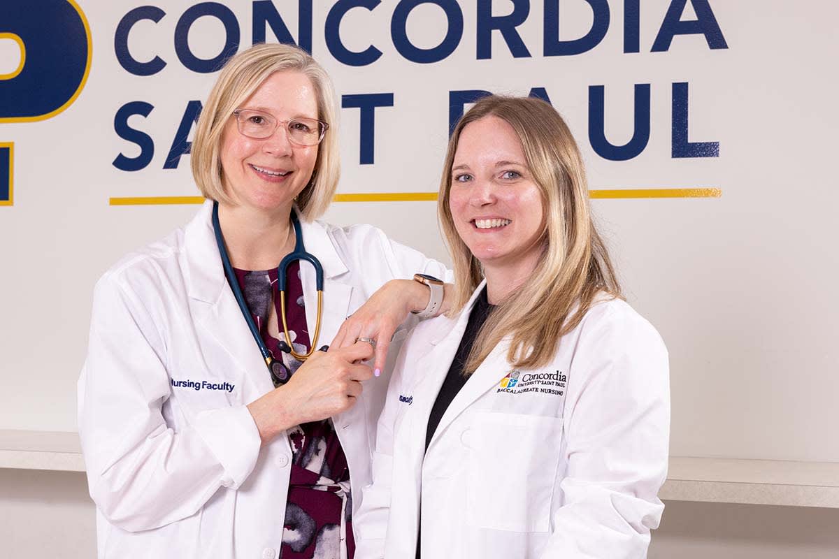 nurses in front of sign