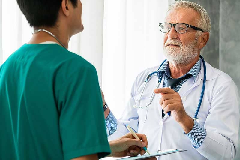 Doctor standing speaking with nurse