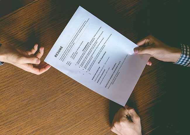 person handing resume to employer