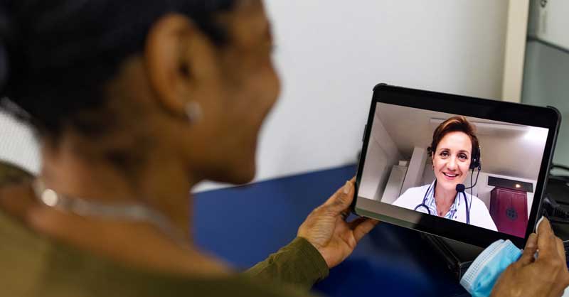 woman speaking to someone on video call using tablet