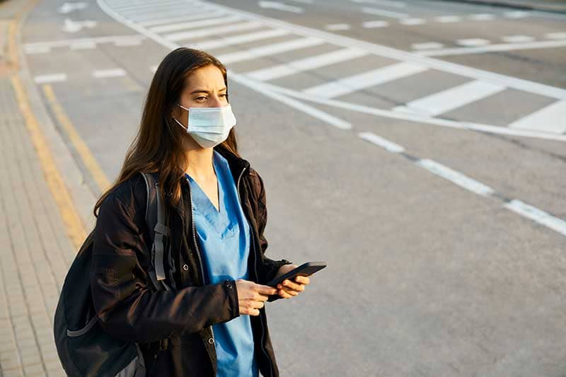 travel nurse standing on sidewalk