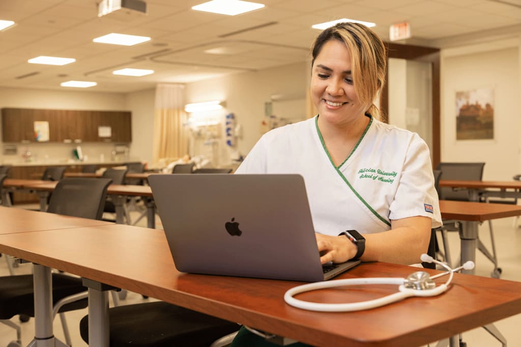 Felician ABSN student using laptop at desk