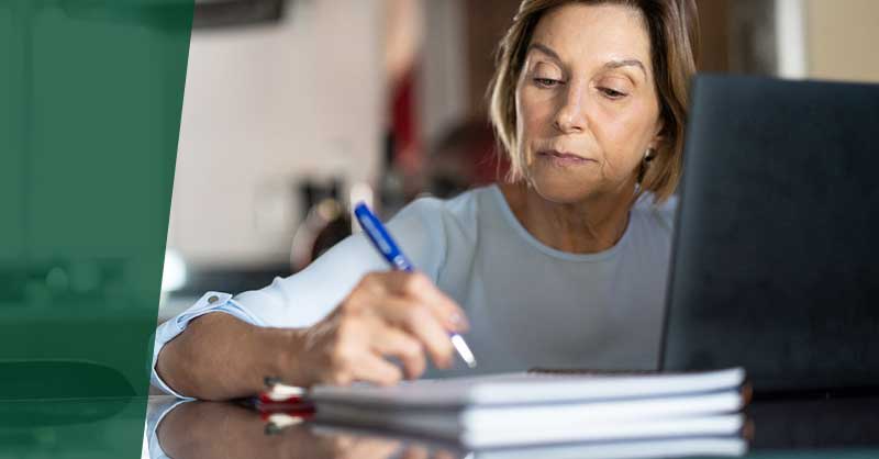 Woman at desk writing in notebook