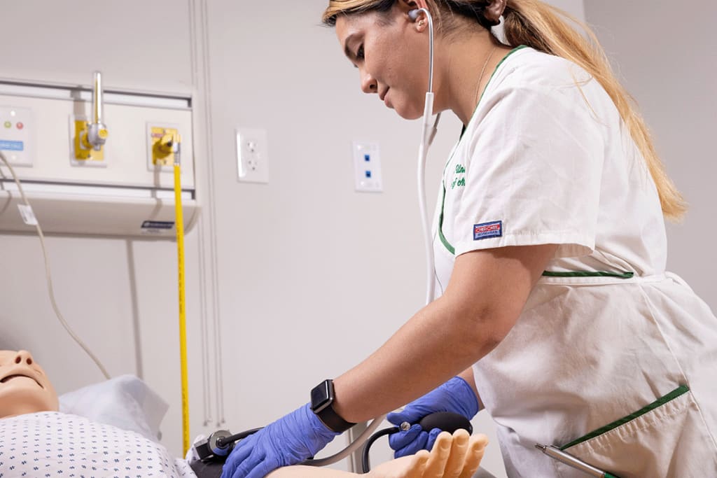 Felician nursing student working on sim manikin